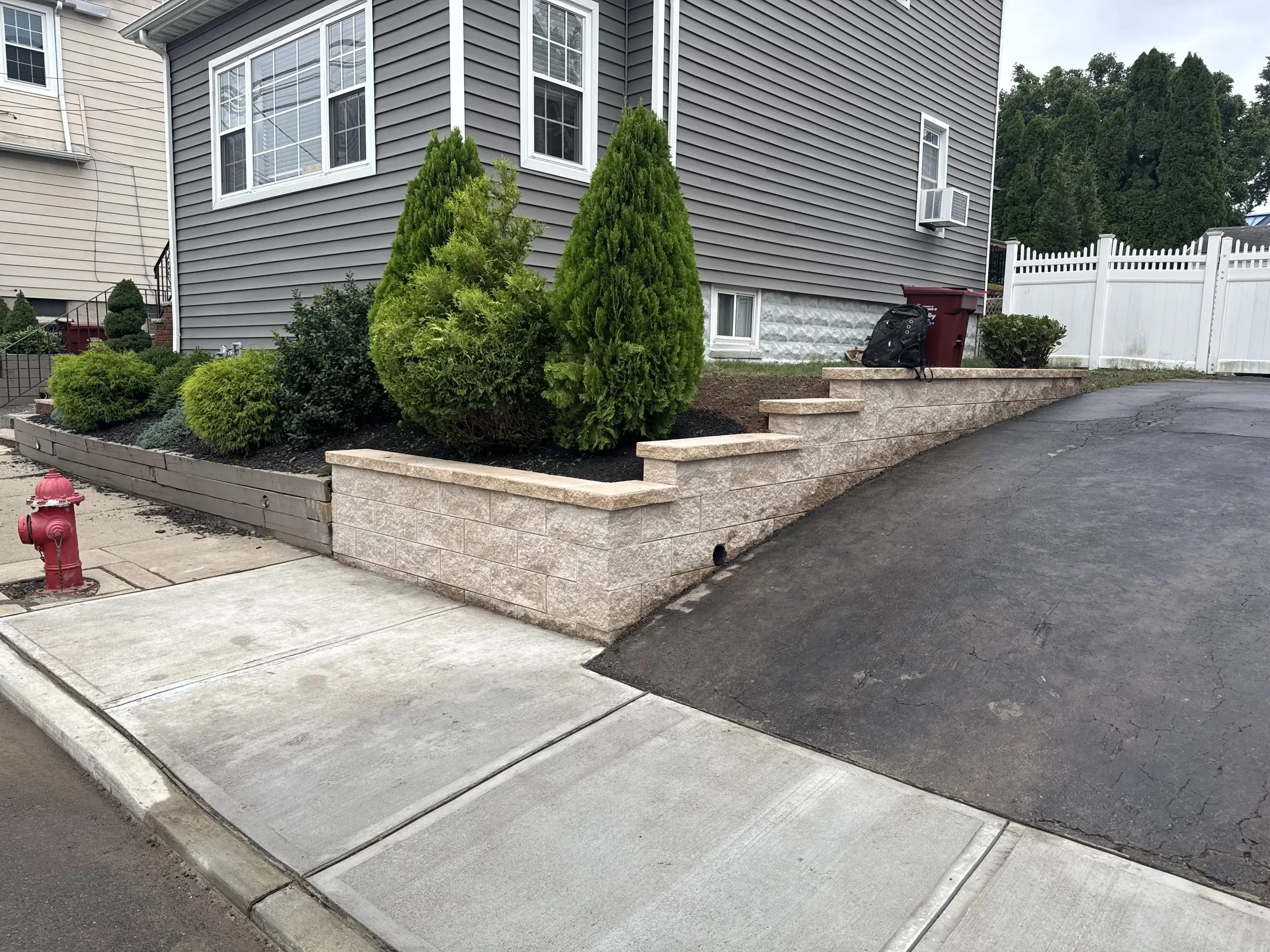 Block retaining wall with steps along a front walkway