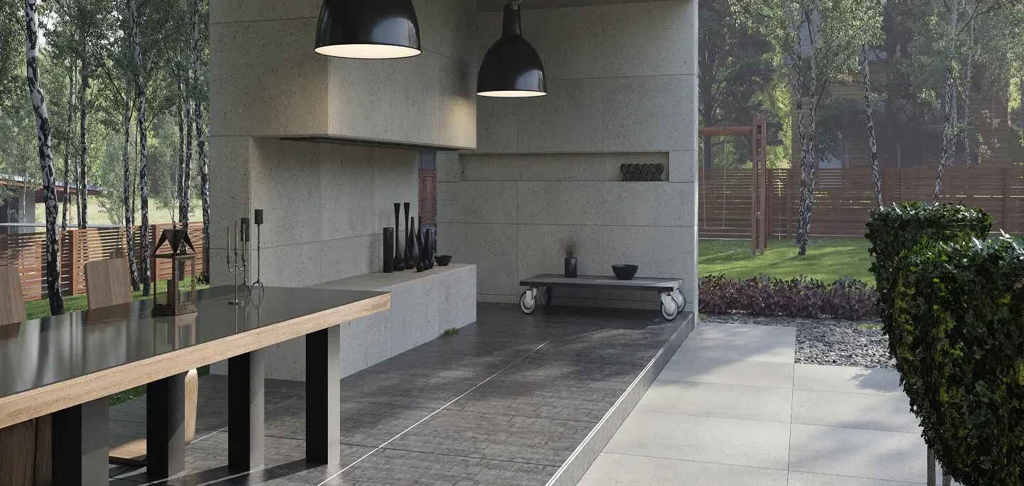Modern outdoor living space with a covered kitchen and large-format stone patio