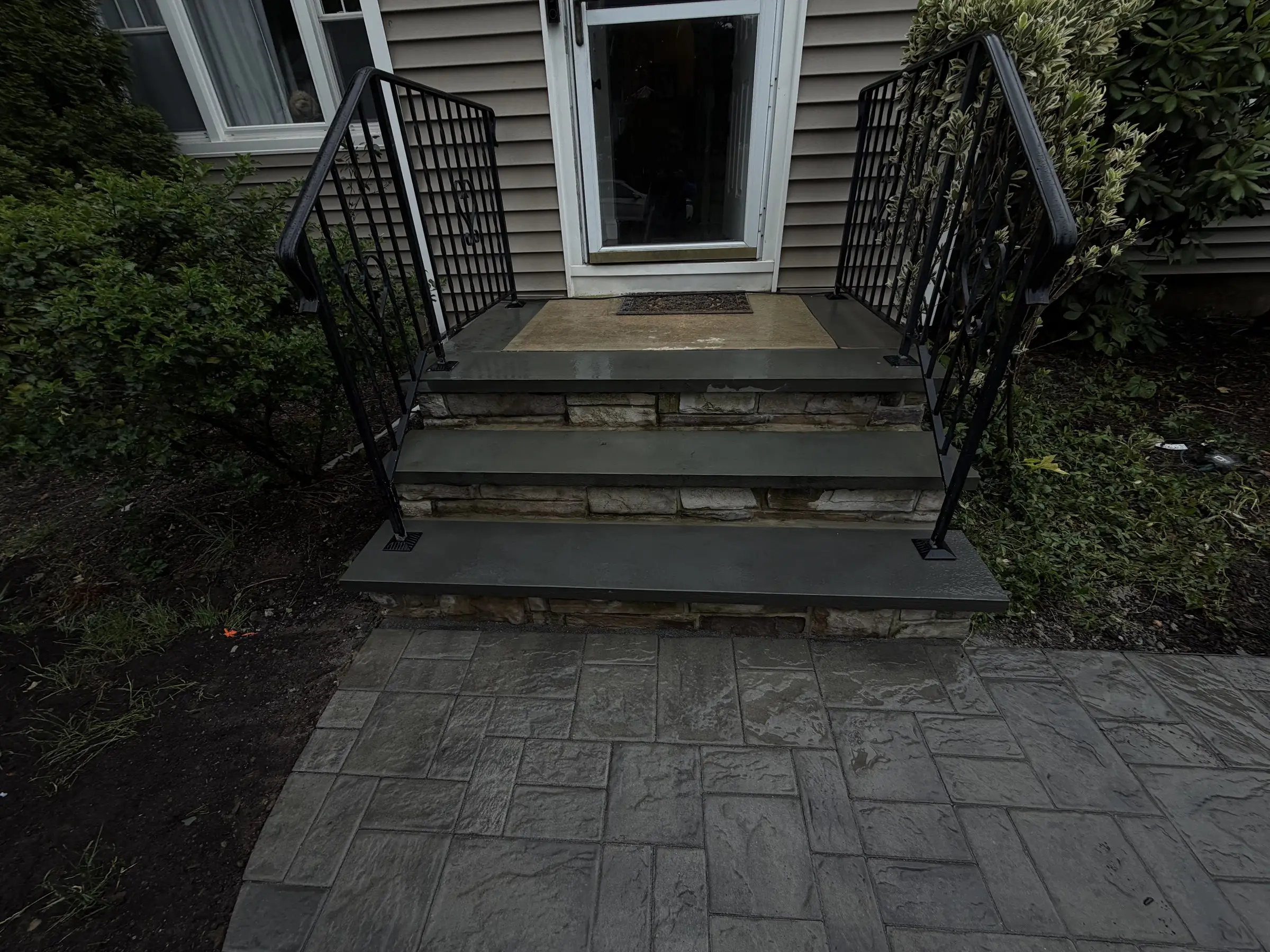 Front entry steps with stone treads leading to a door